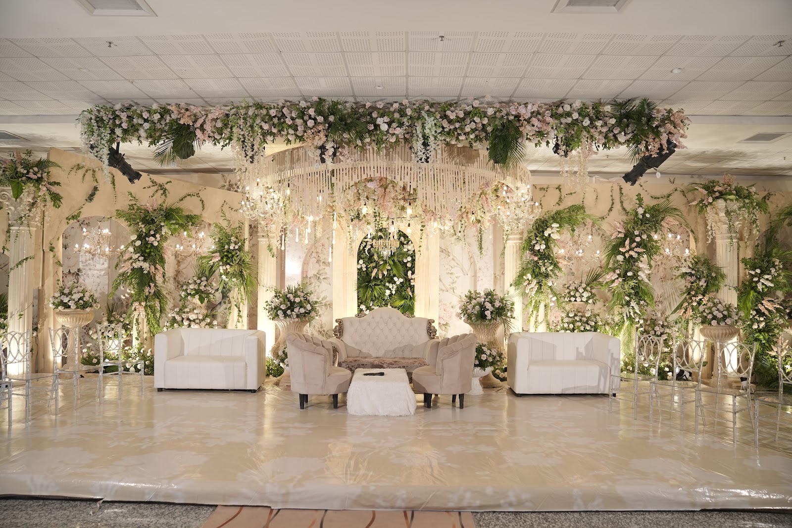 Prestige wedding stage framed by white florals and crystal chandeliers